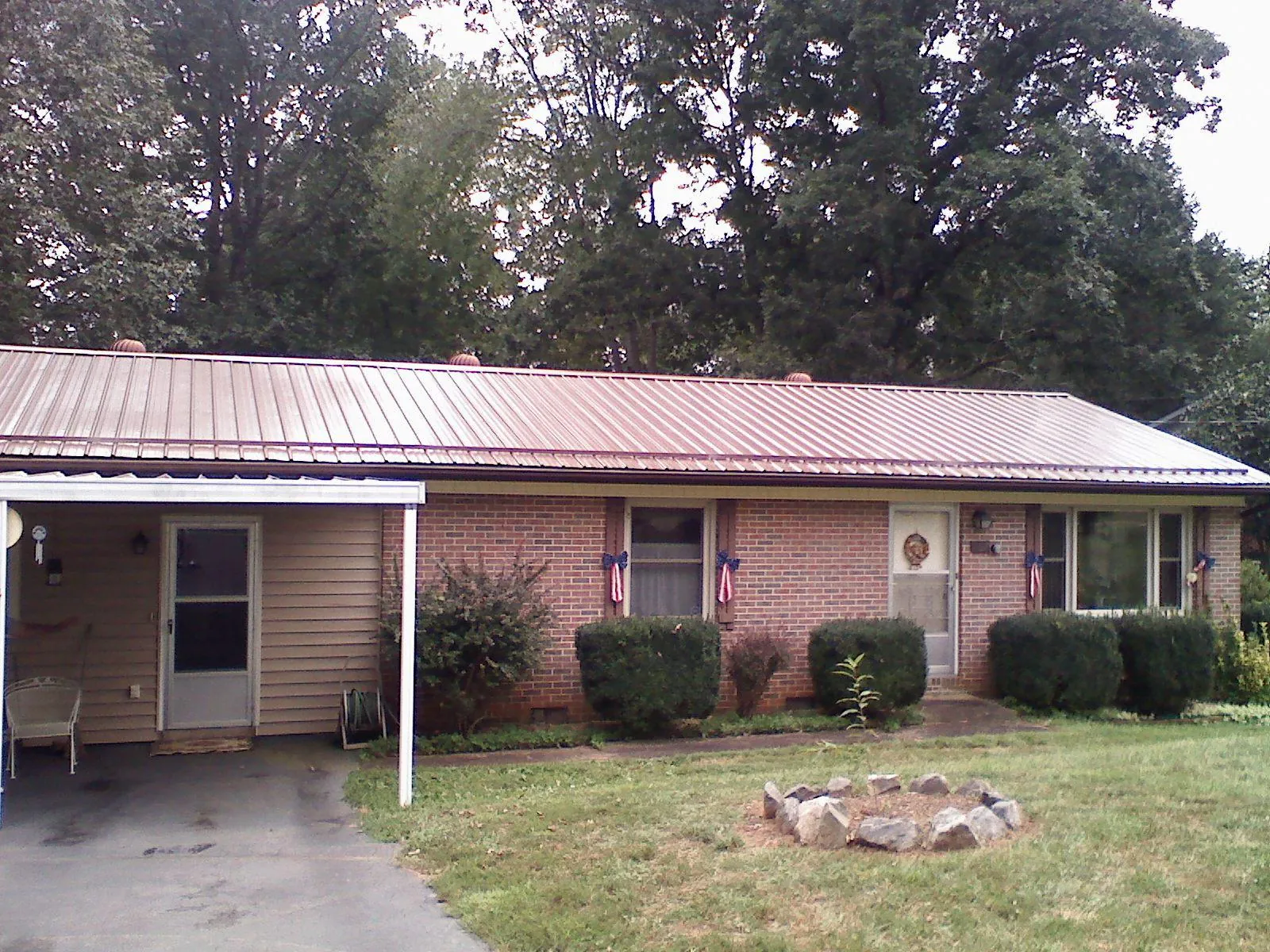 Bronze metal roof and carport on a brick ranch home — Roof Repair work by our crew in Pantego
