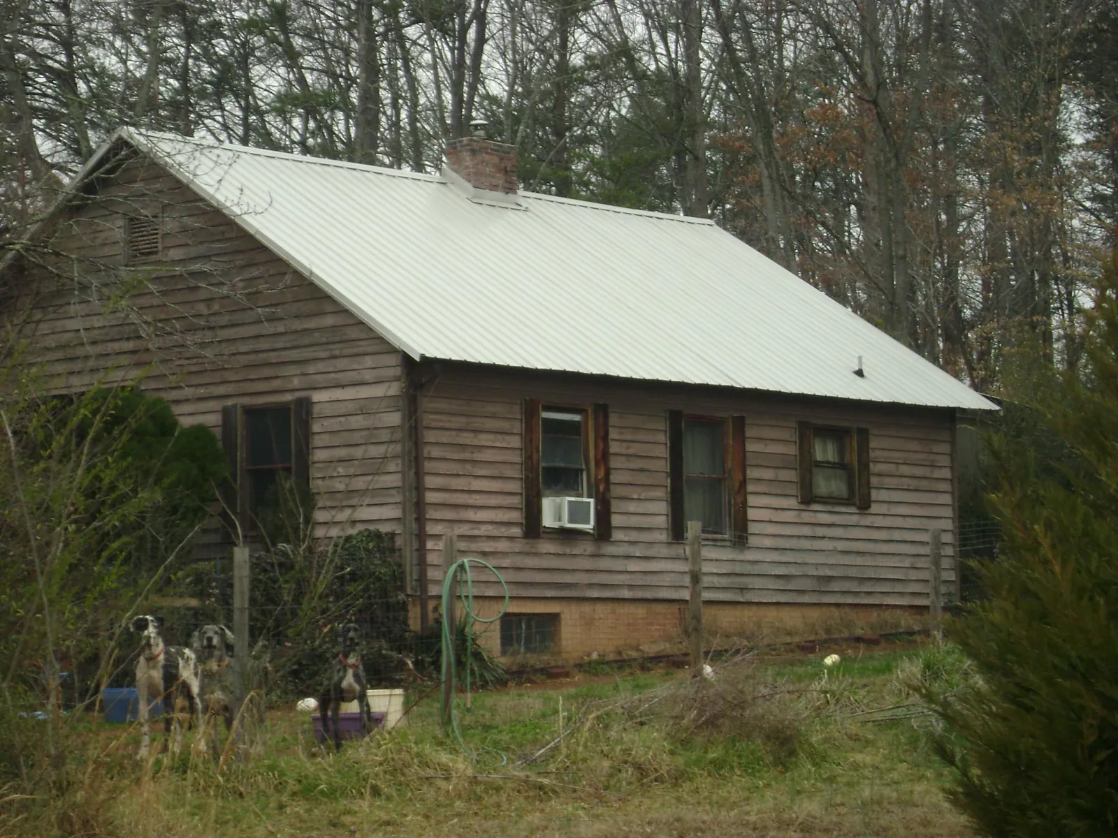 White metal roof on an old wood sided farmhouse, from a Metal Roof Installation job in Pantego
